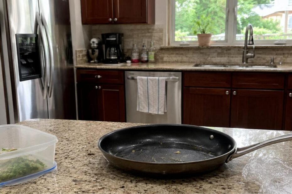 Cocina doméstica realista con sartén antiadherente, recipiente de plástico y papel film sobre encimera de granito